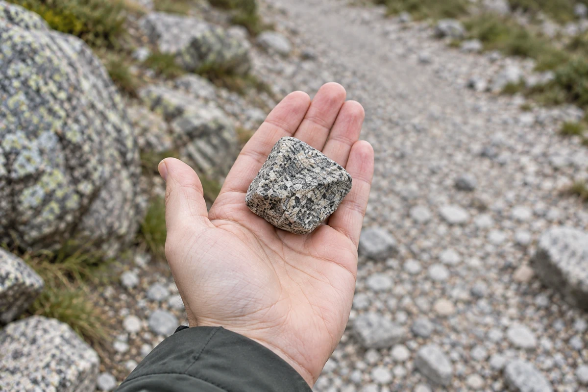 A rough granite stone photographed in an open palm